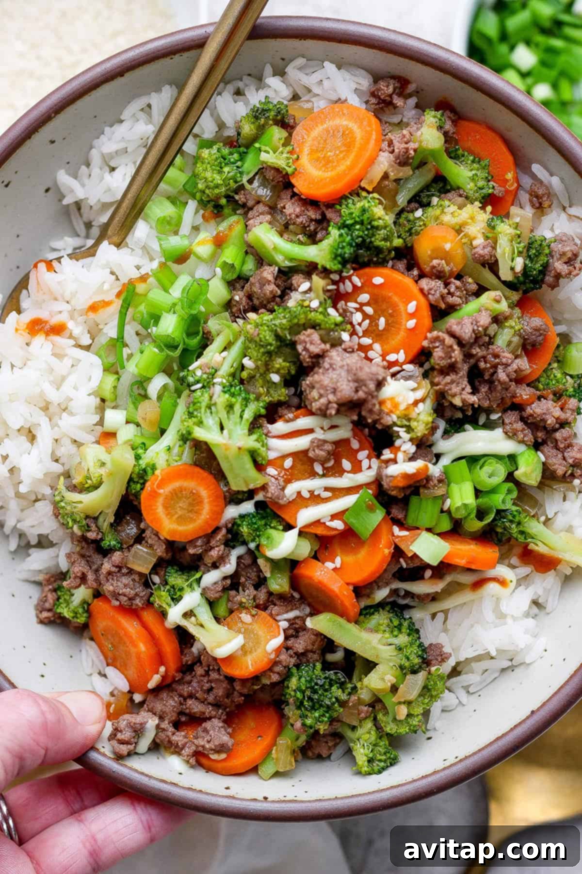 Ground Beef with Broccoli Florets 7 A close-up of a bowl of ground beef and broccoli over rice, garnished with chopsticks.