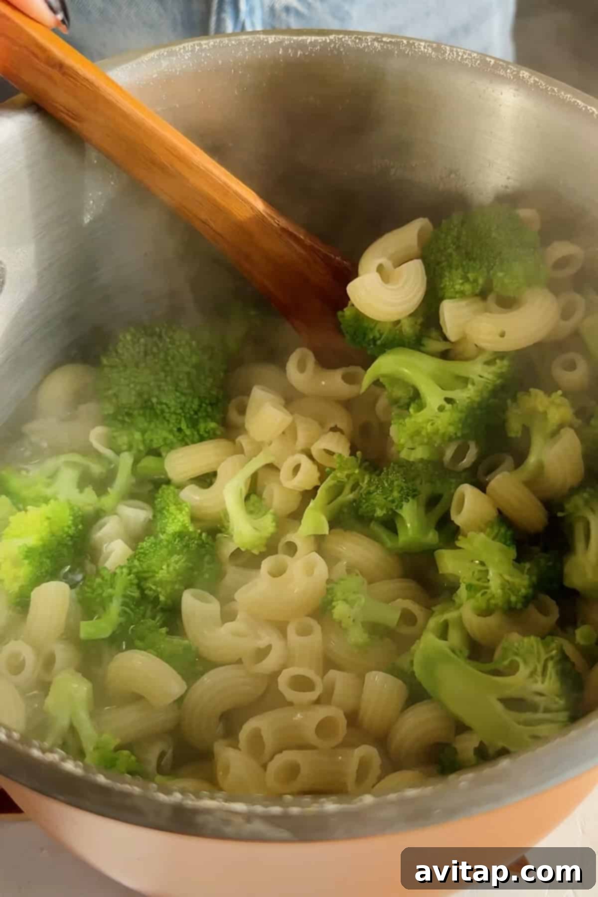 Pasta and broccoli boiling in a pot.