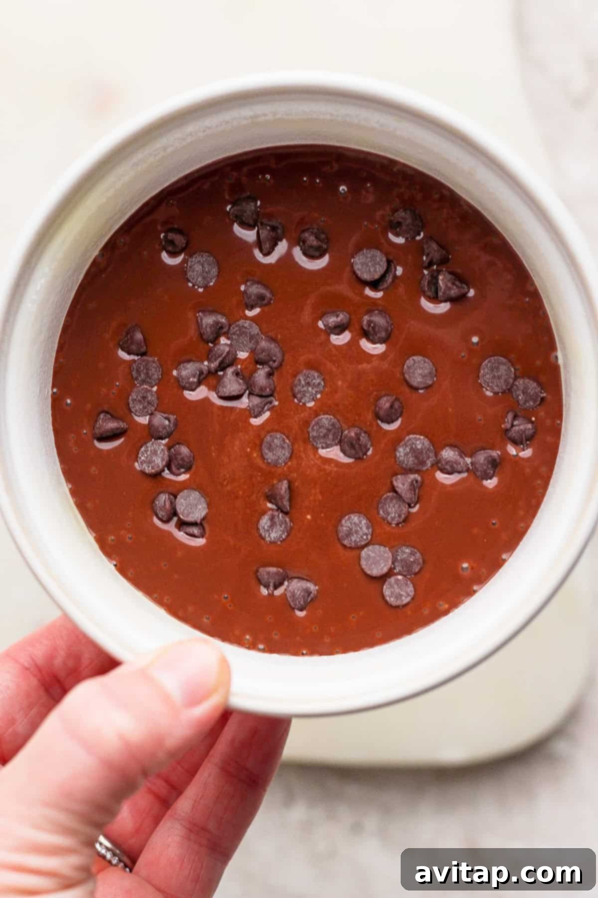 Batter in a ramekin topped with chocolate chips