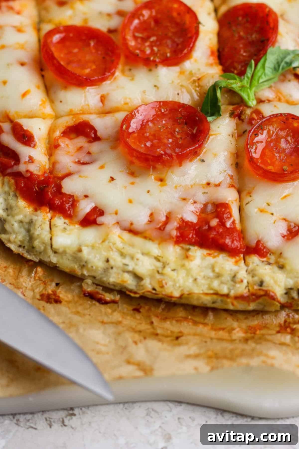 A perfectly sliced chicken crust pizza on a cutting board, garnished with fresh basil, ready to be enjoyed.
