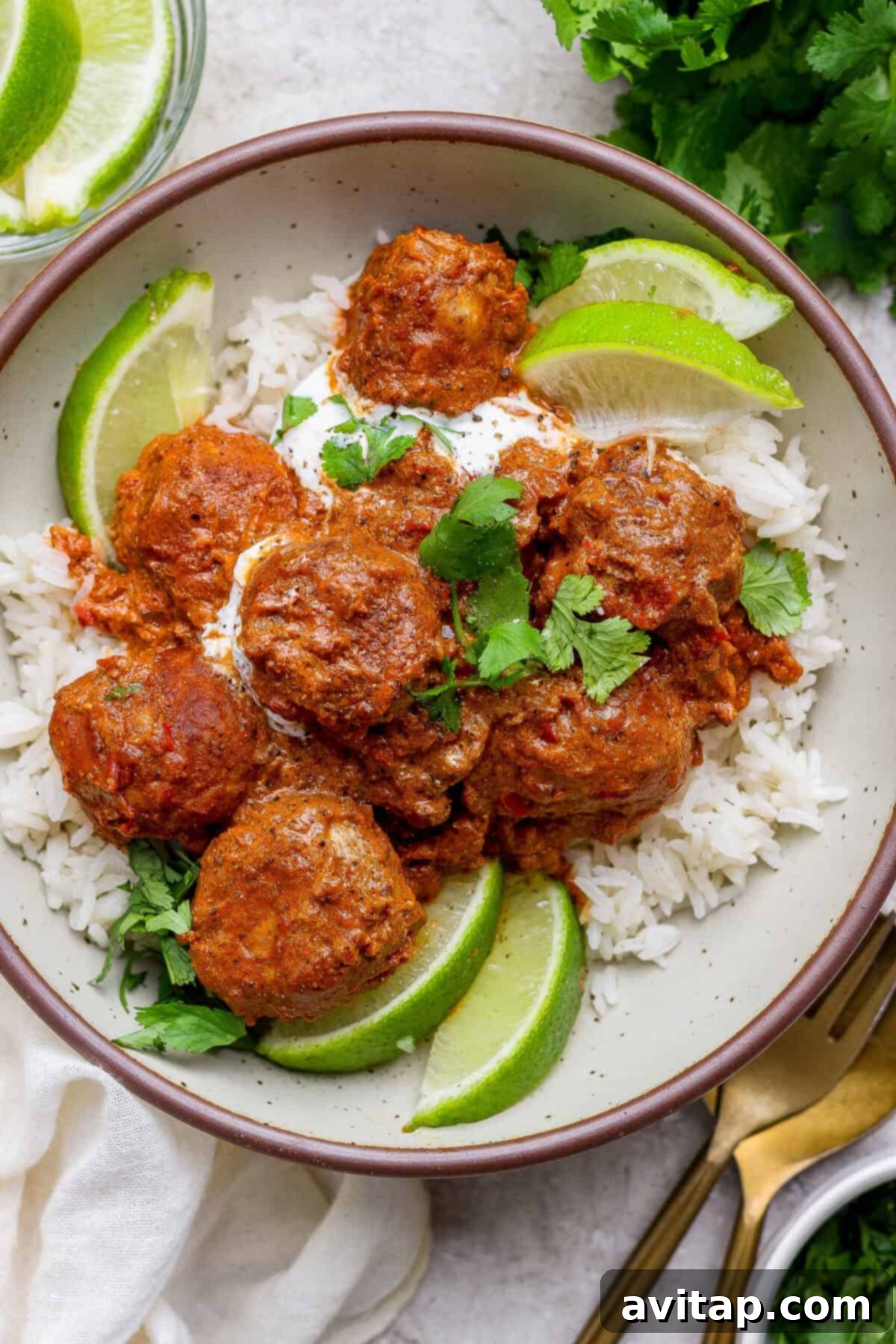 Butter chicken meatballs served over rice with lime and cilantro
