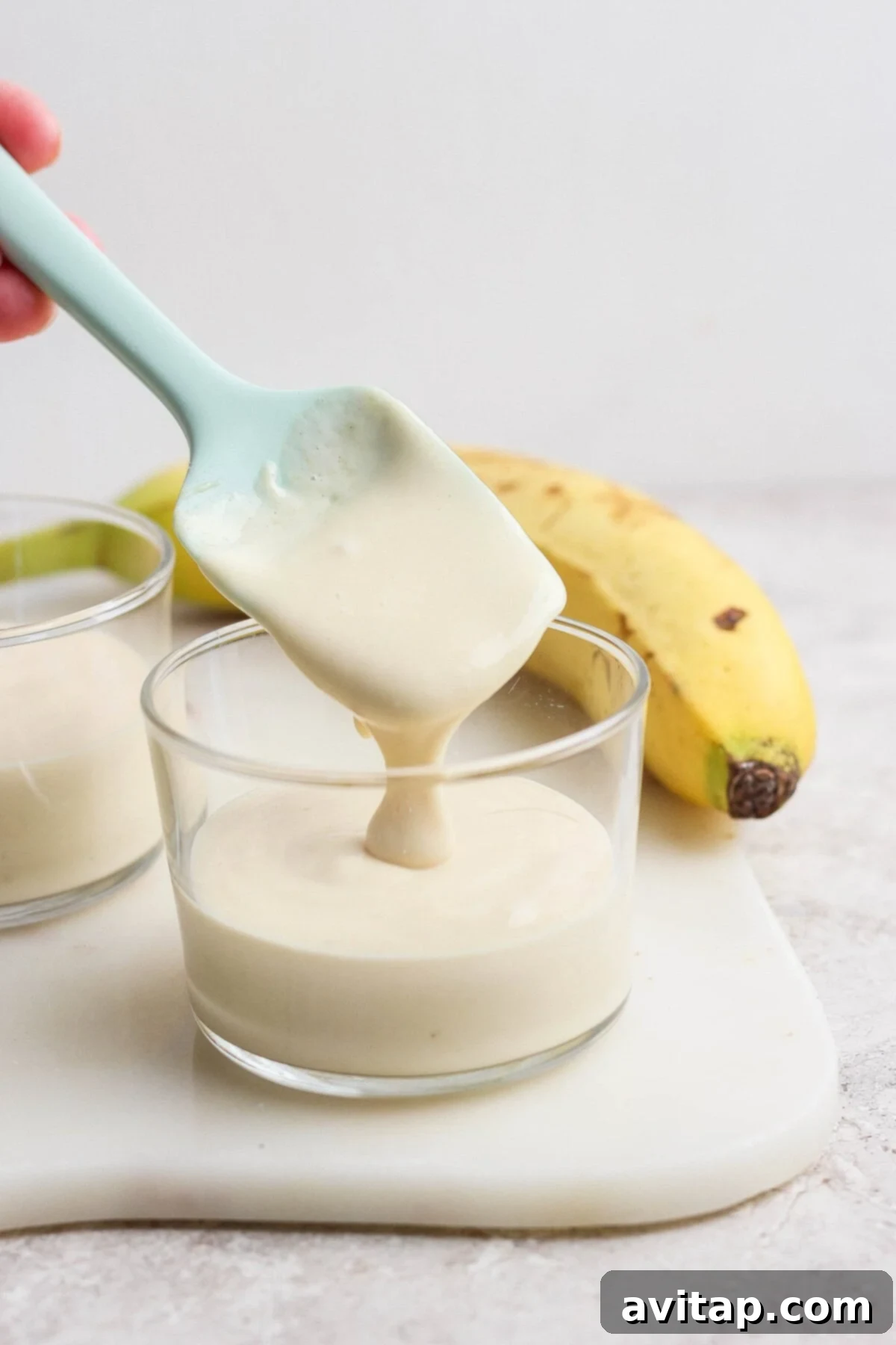 High-Protein Banana Bliss 4 Scooping creamy banana pudding from a glass cup