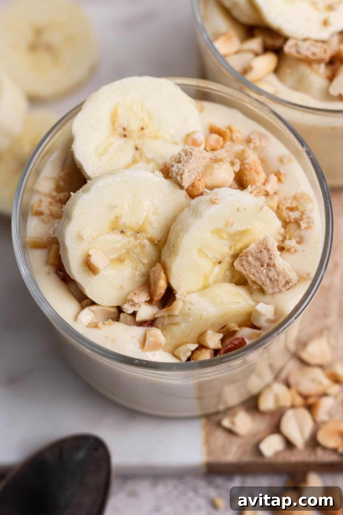 High-Protein Banana Bliss 6 Bowl of banana pudding topped with banana slices, nuts, and cookie pieces