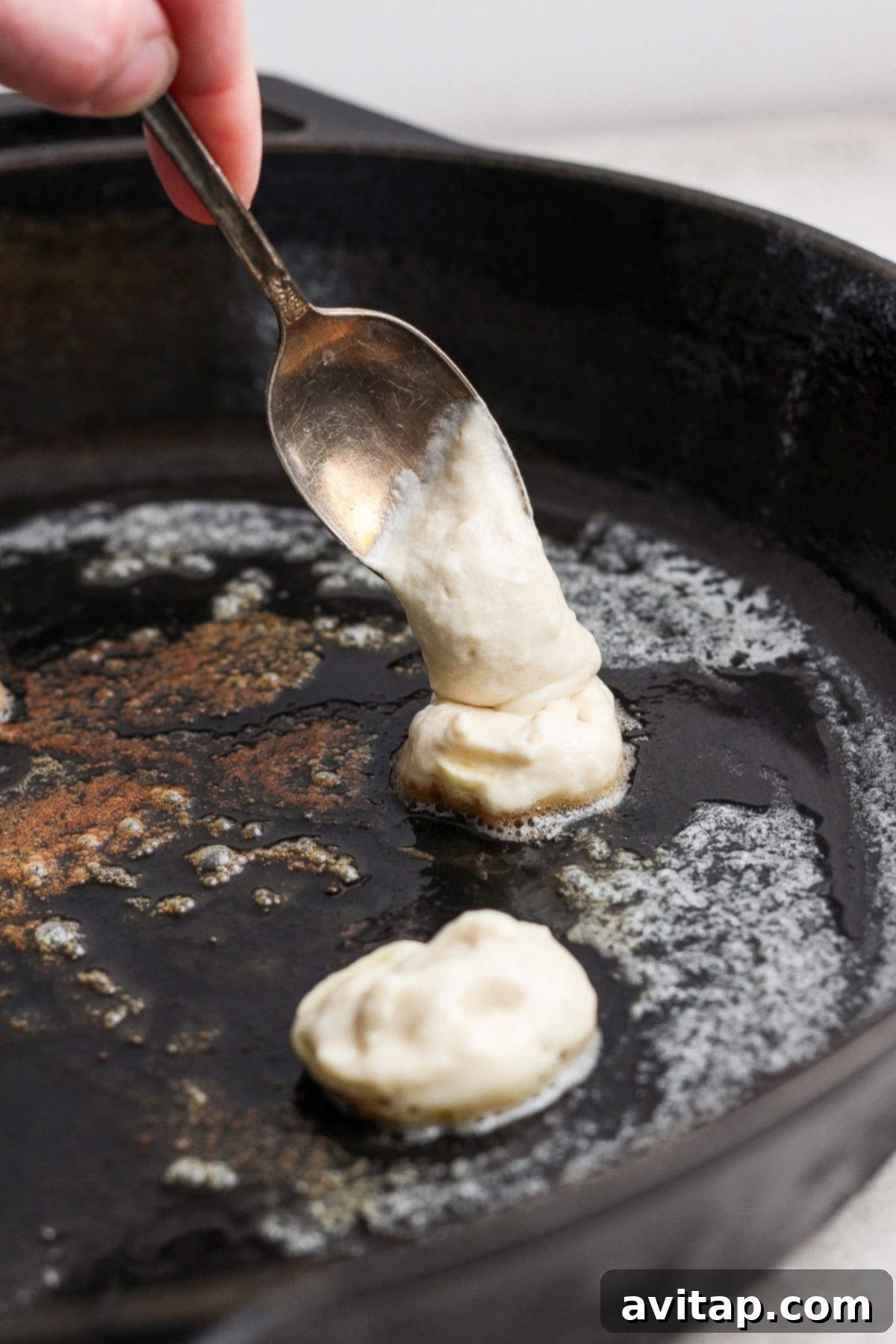 Cooking mini banana pancakes in a skillet