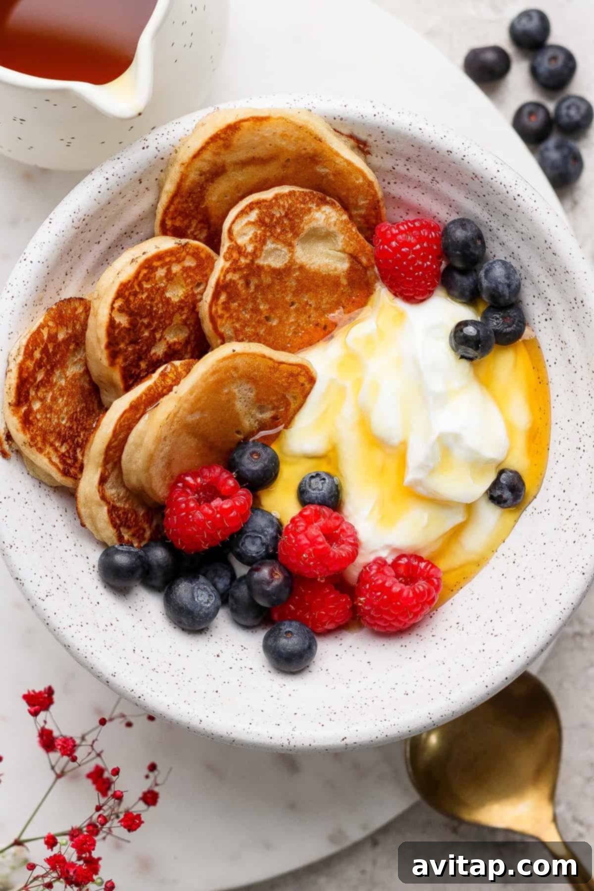Mini pancakes served in a bowl with yogurt and berries