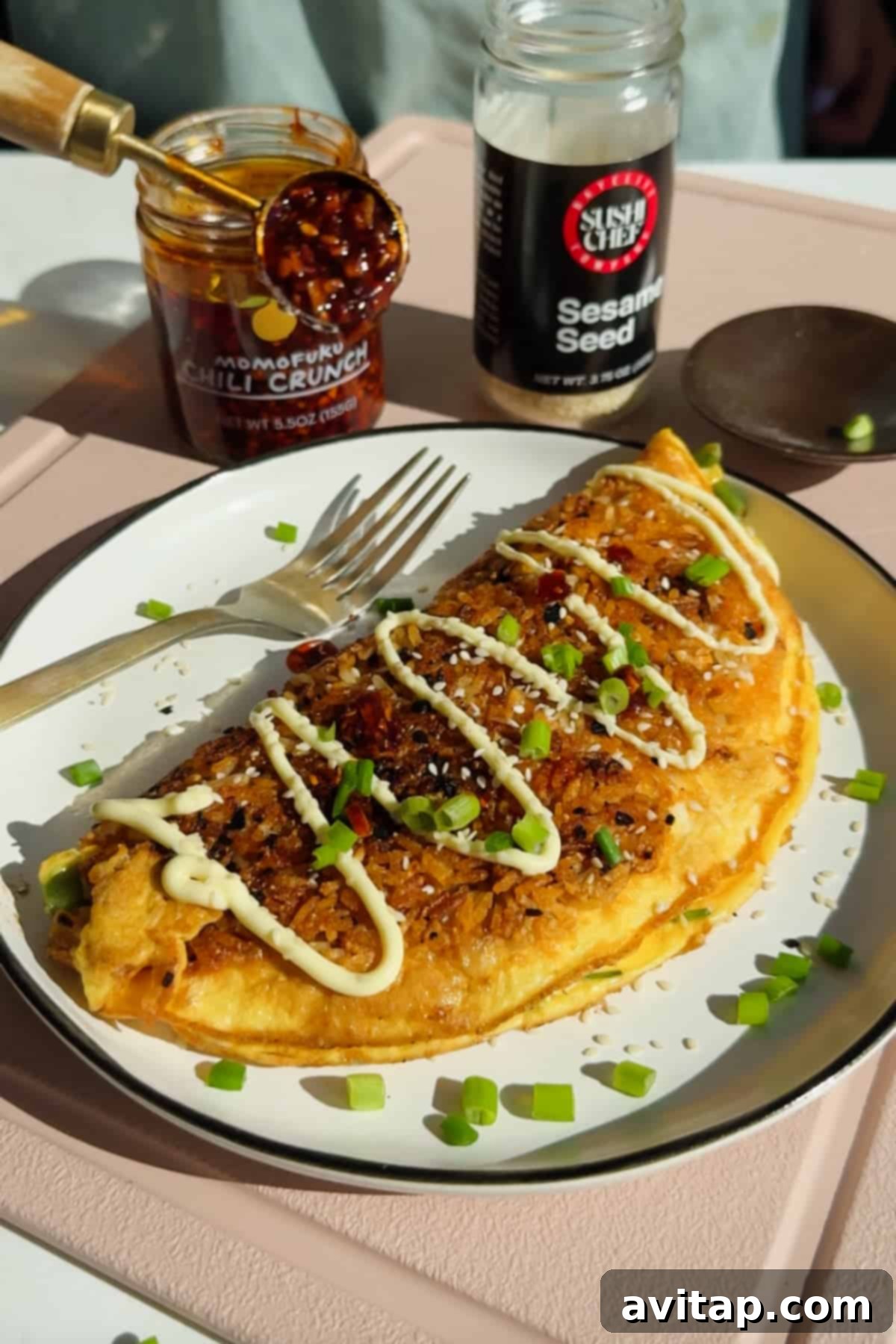Crispy Rice Omelet Delight 2 Crispy Fried Rice Omelette topped with mayonnaise, chili crunch, sesame seeds, and green onions.