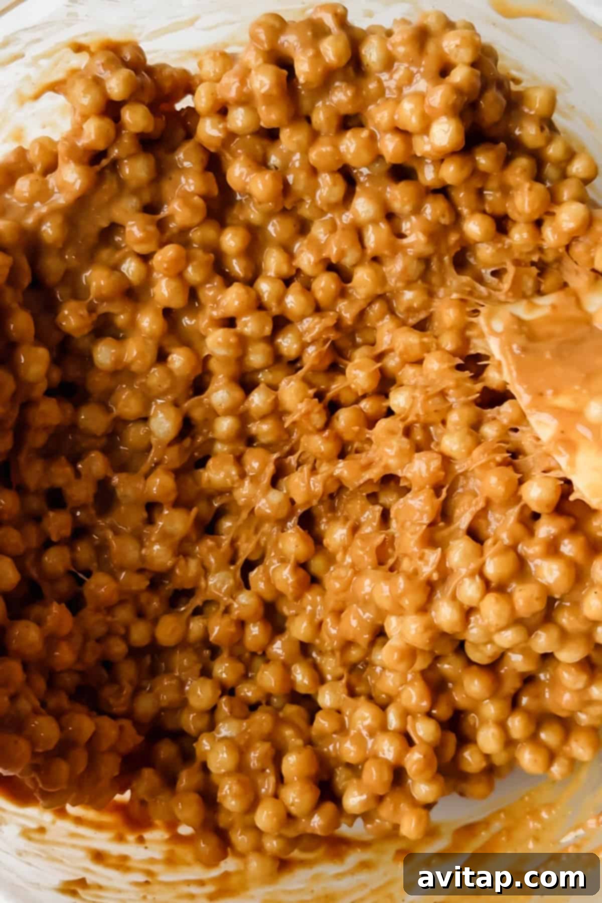 Close-up of peanut butter and puffed quinoa mixture in a bowl.