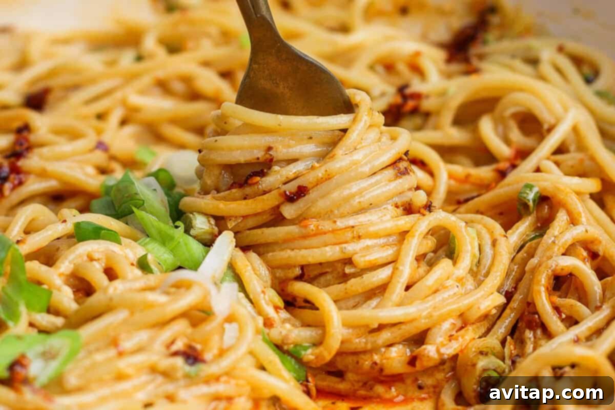 A close-up shot of Tahini Chili Oil Noodles, showcasing the creamy sauce and garnished green onions.