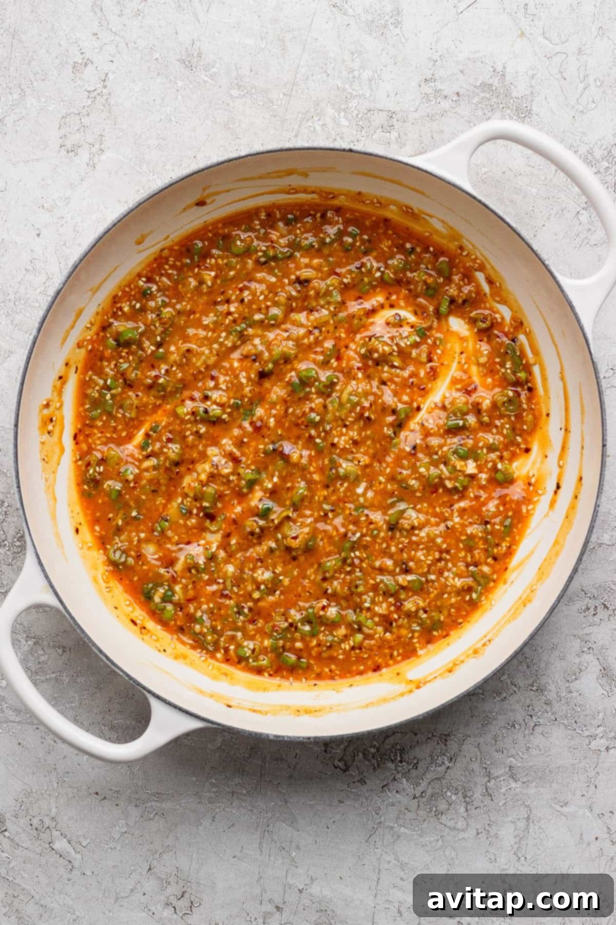 The chili oil sauce simmering in a pan, ready to be tossed with the noodles.