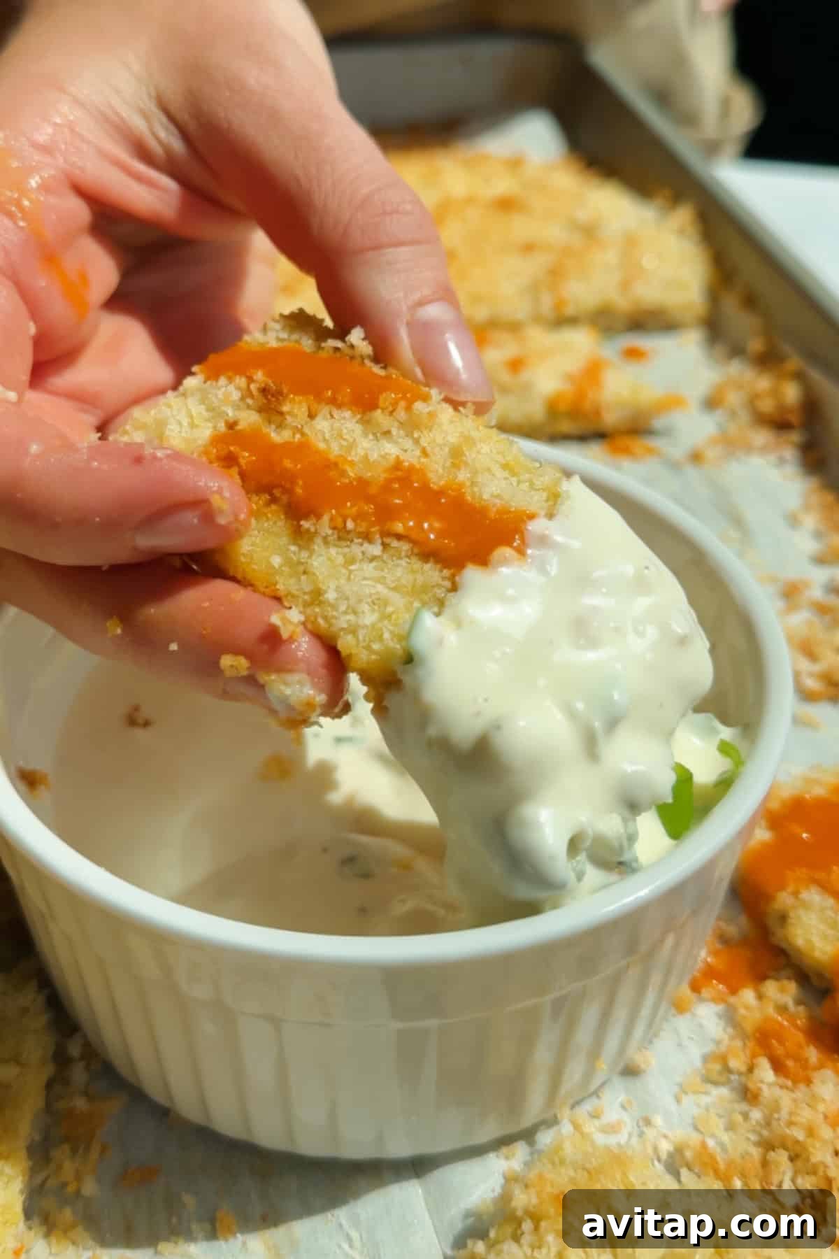 Buffalo Chicken Protein Bars — Crispy Baked Snackable Bars 2 Dipping a buffalo-sauced chicken protein bar into creamy blue cheese dressing