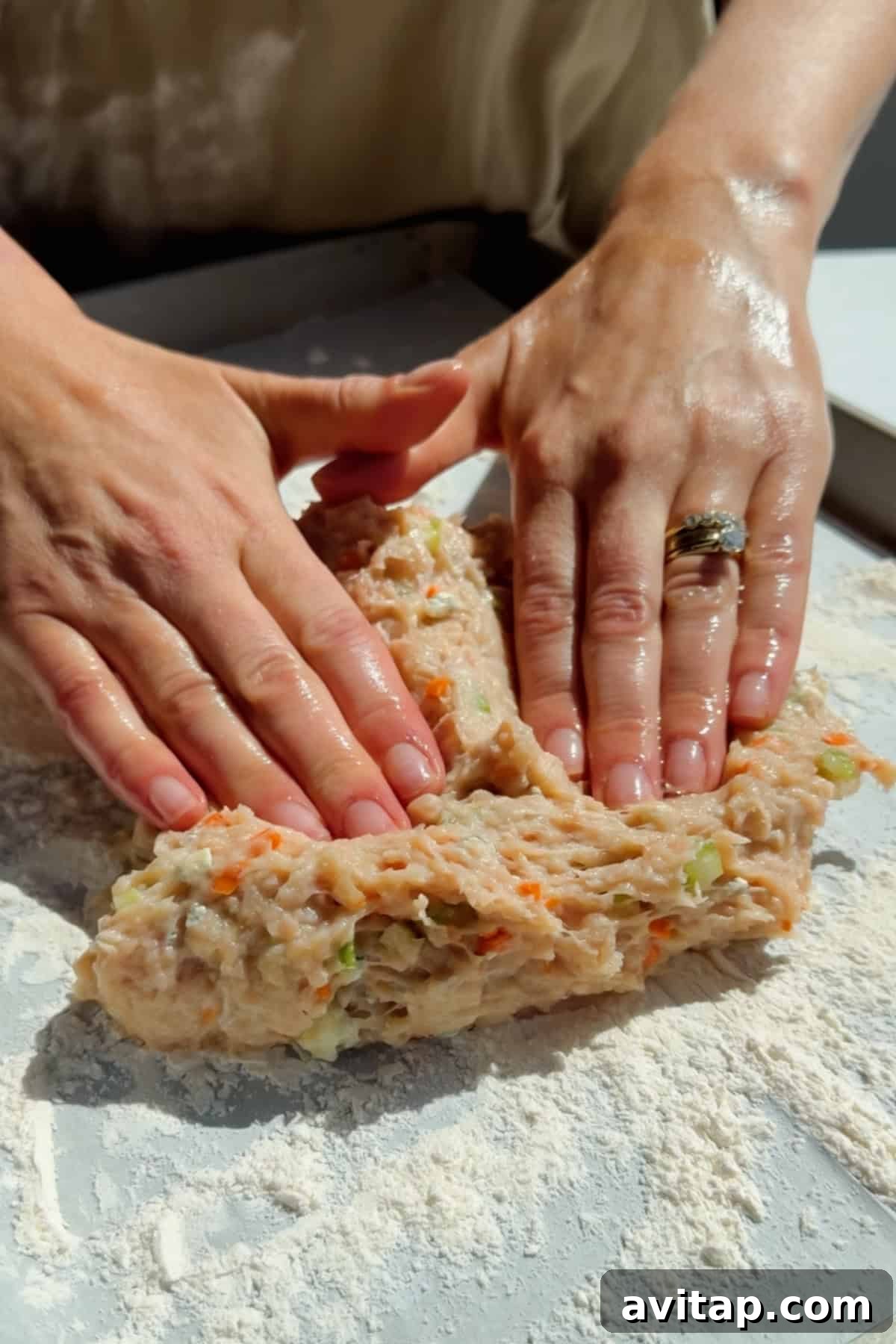 Buffalo Chicken Protein Bars — Crispy Baked Snackable Bars 5 Pressing and shaping ground chicken protein bar mixture with vegetables on parchment paper