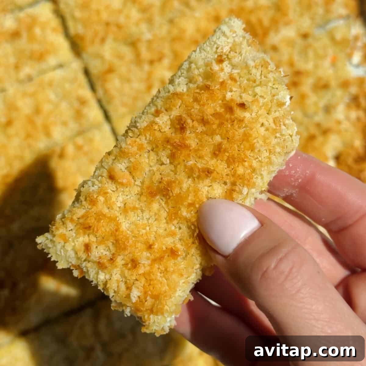 Buffalo Chicken Protein Bars — Crispy Baked Snackable Bars 9 Holding a golden brown chicken protein bar with crispy panko and parmesan crust