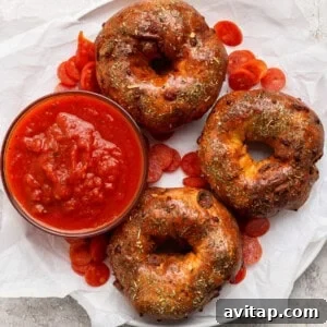 Pizza protein bagels with Italian seasoning served with marinara sauce and pepperoni slices