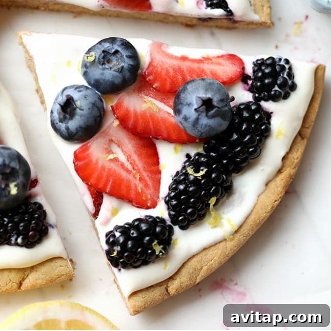 A slice of pizza with berries and lemon on it.