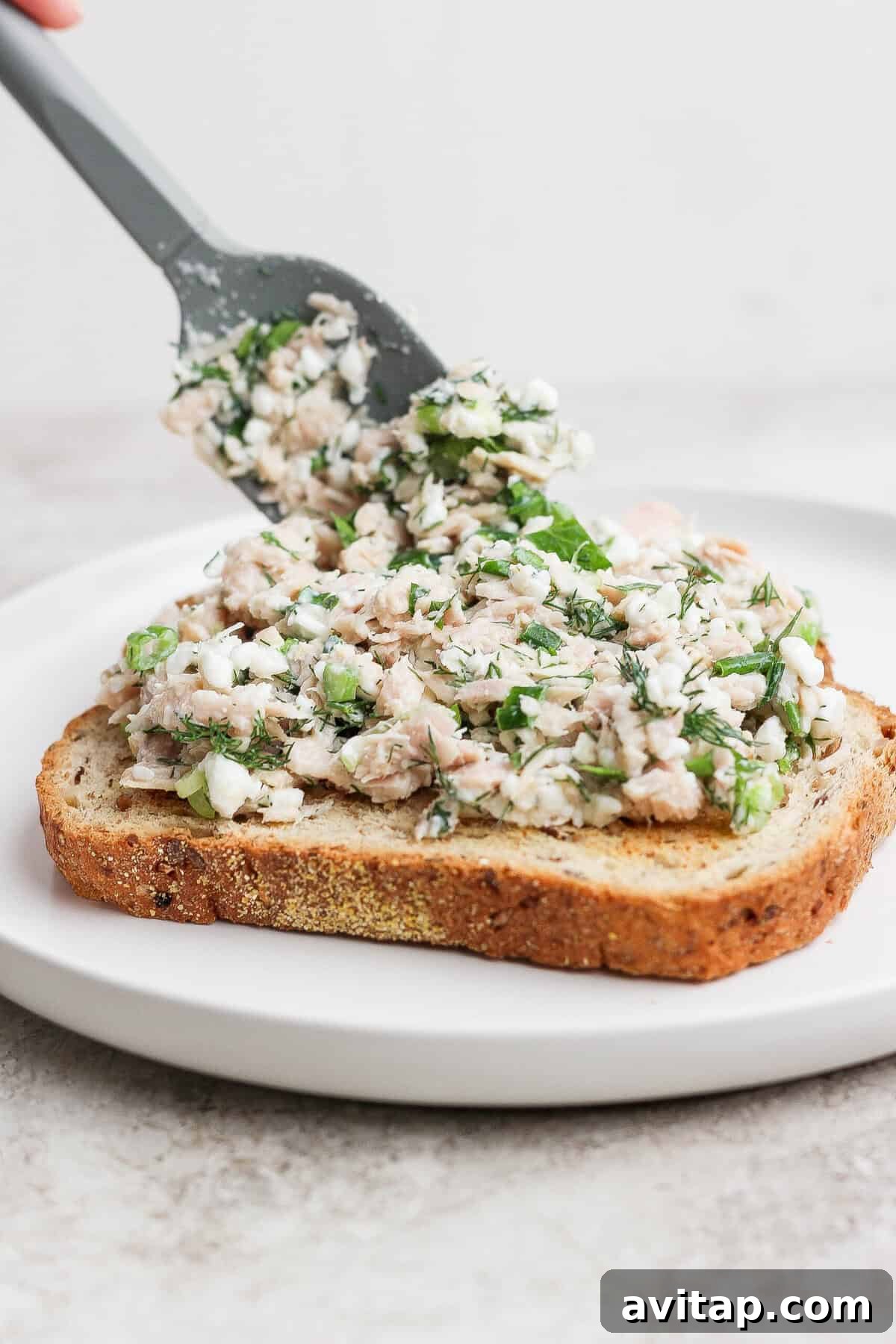 spreading cottage cheese tuna salad on sourdough toast