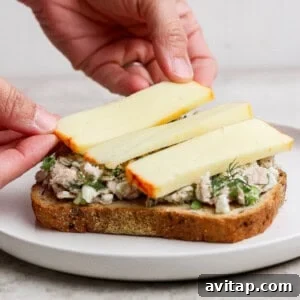 placing muenster cheese slices on tuna melt