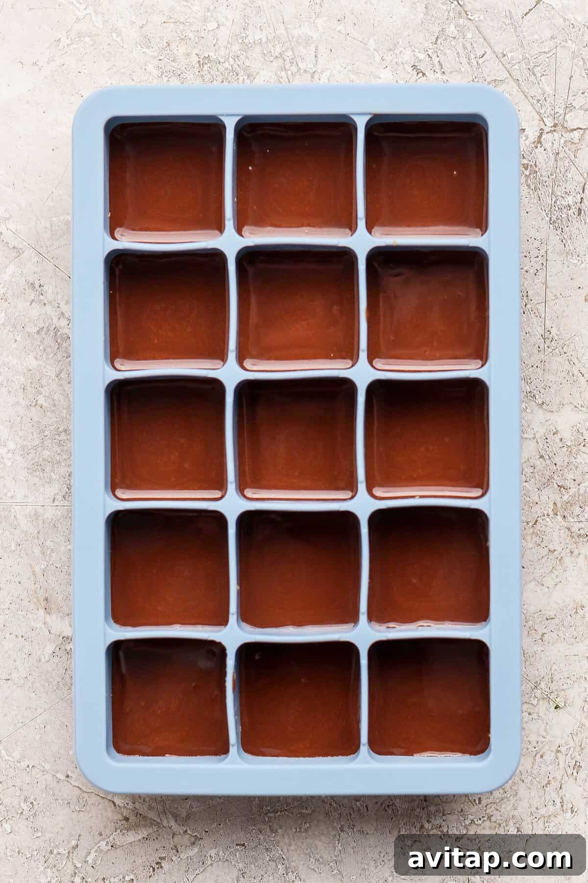 thin mint protein bites covered with melted chocolate layer in a blue silicone ice cube tray