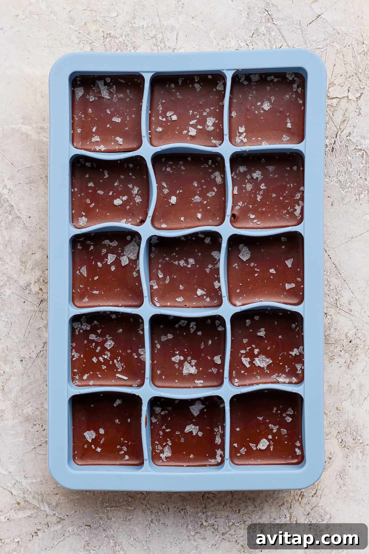 thin mint protein bites topped with flaky sea salt in a blue silicone tray before freezing