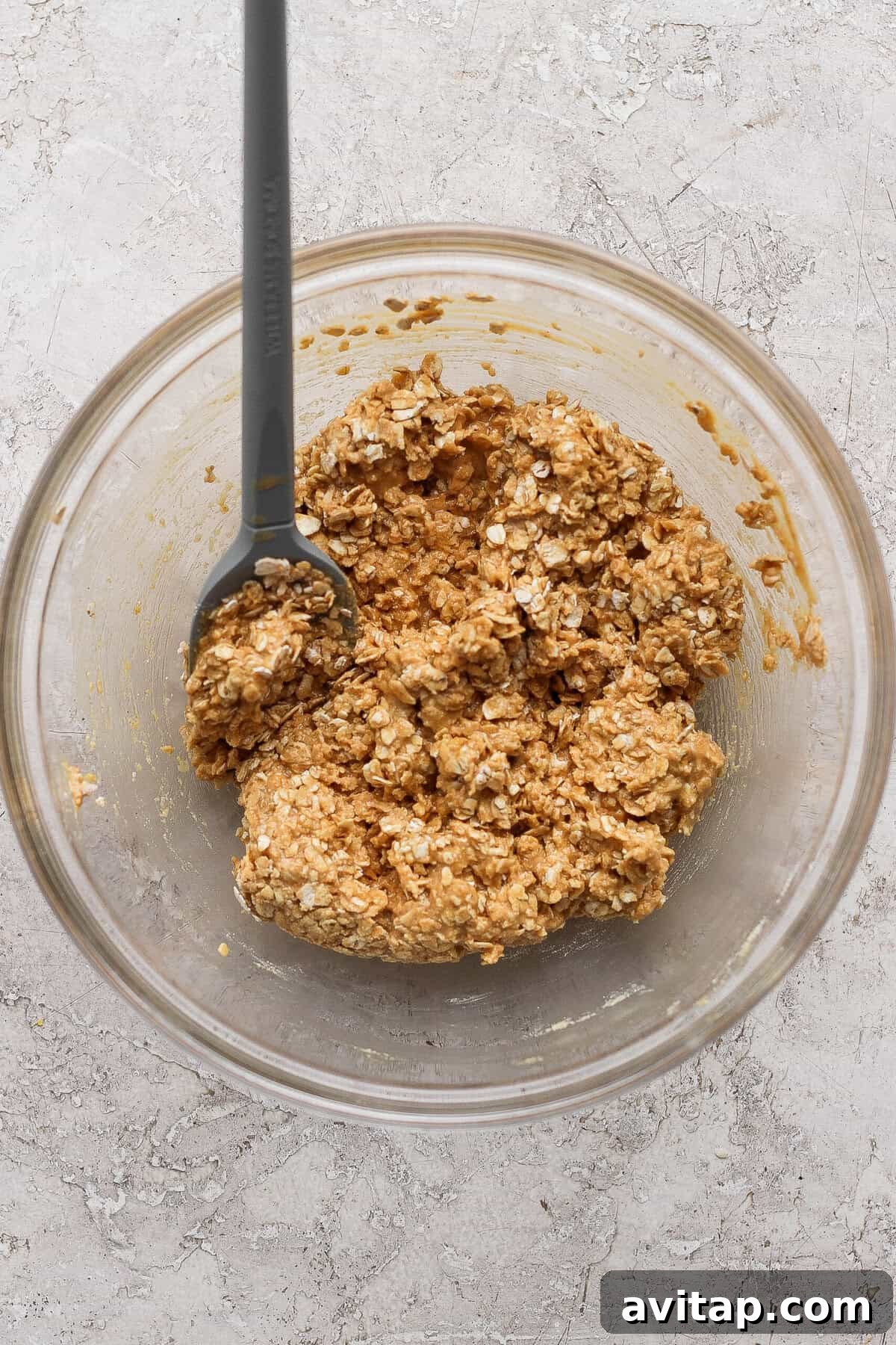 stirring peanut butter oat crumble topping with a spatula until clumpy
