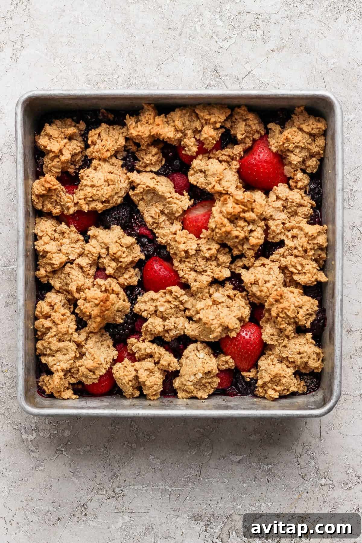 golden brown protein berry crumble fresh out of the oven in a baking pan