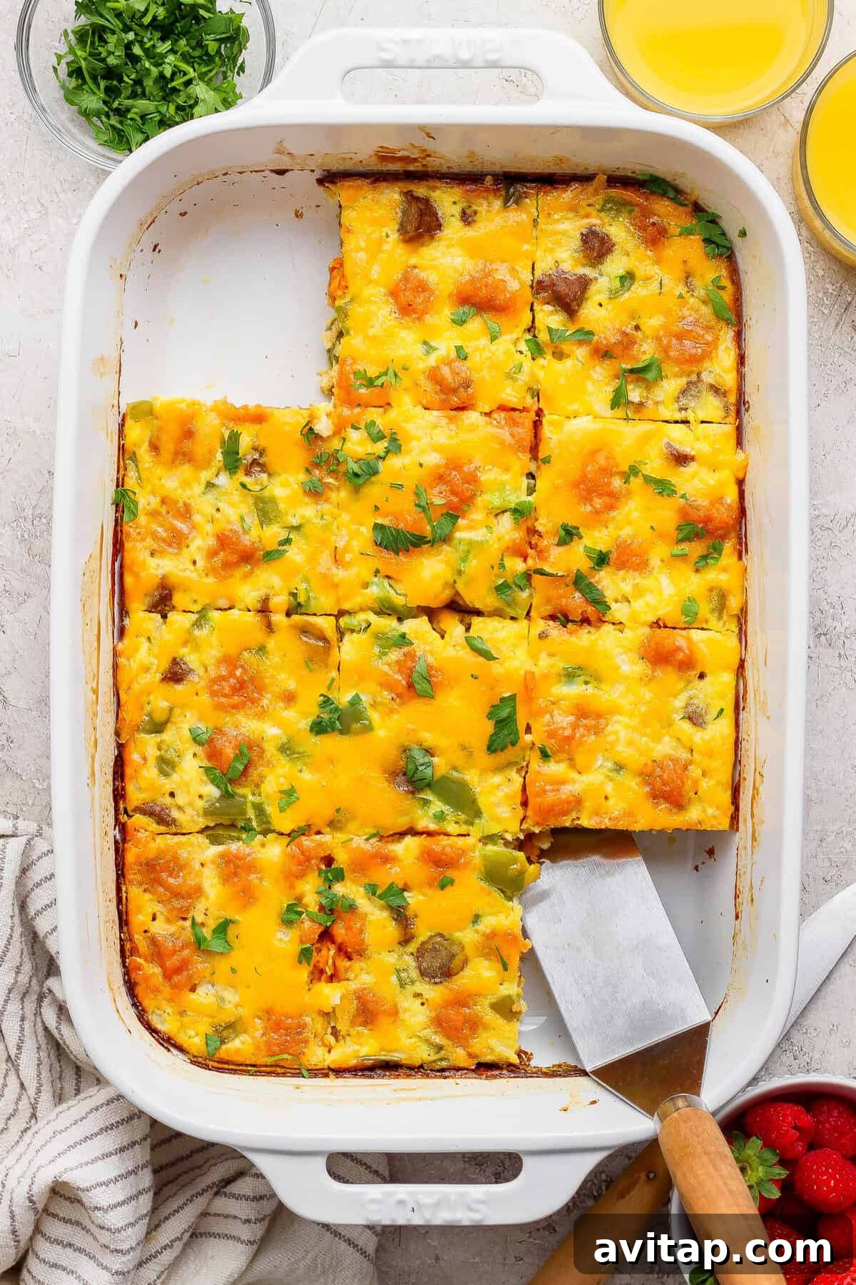 sweet potato breakfast casserole sliced into squares with a piece being lifted out