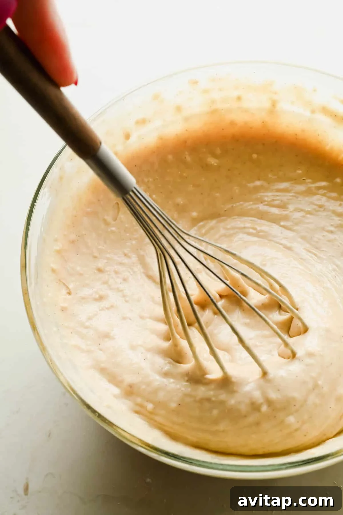 Almond sheet pan pancake batter being whisked in a glass bowl.